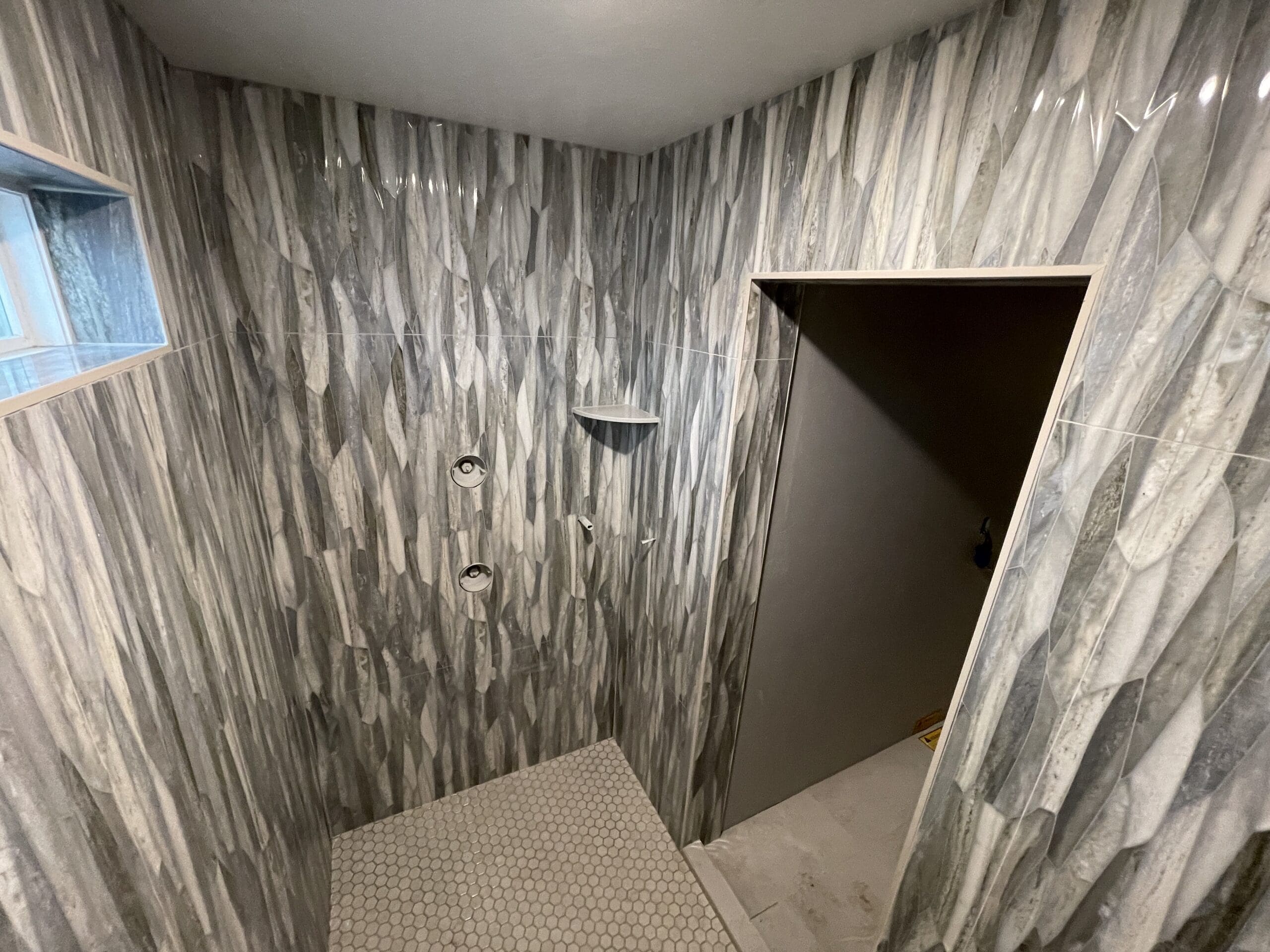 Veined marble-look shower tile installation